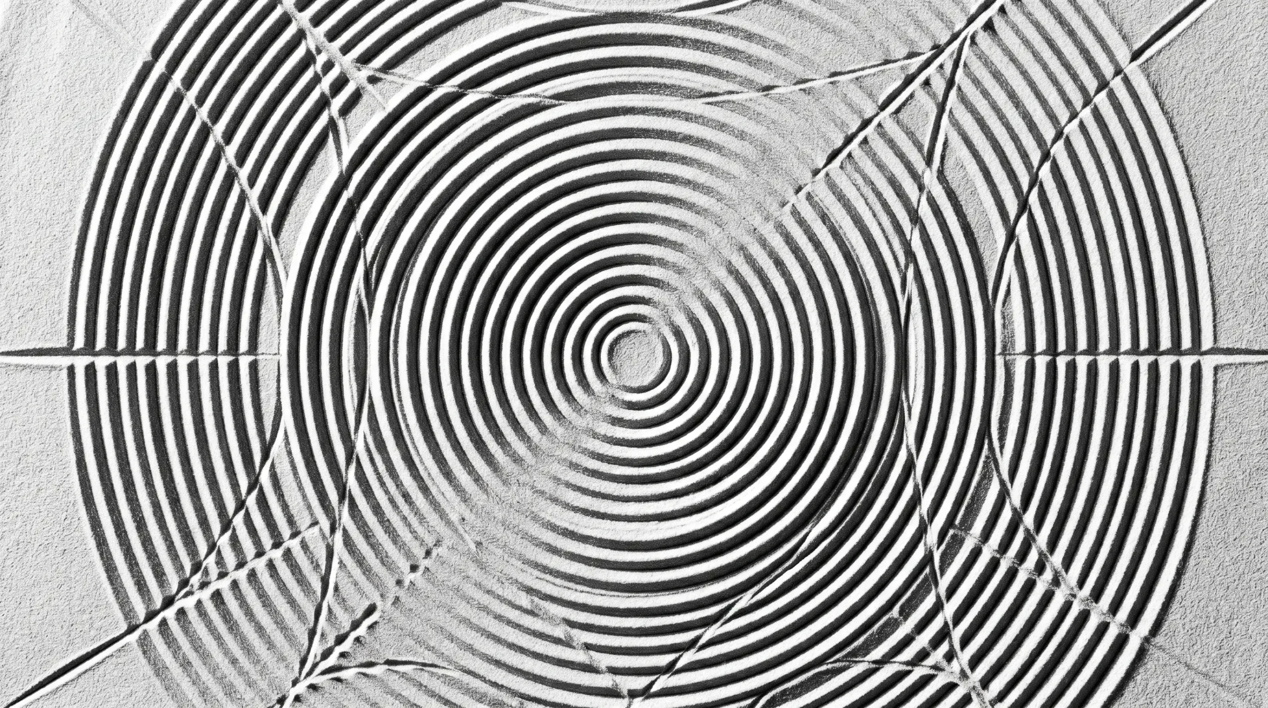 Vue en plongée verticale de cercles concentriques parfaitement gravés dans du sable blanc, symbolisant les différentes strates de l'écoute active en closing